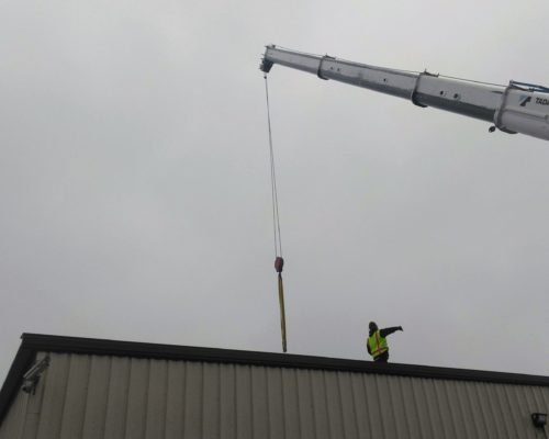 ITS Team Member Directing Crane On Roof Top