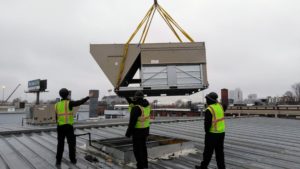 Men installing new HVAC unit on rooftop