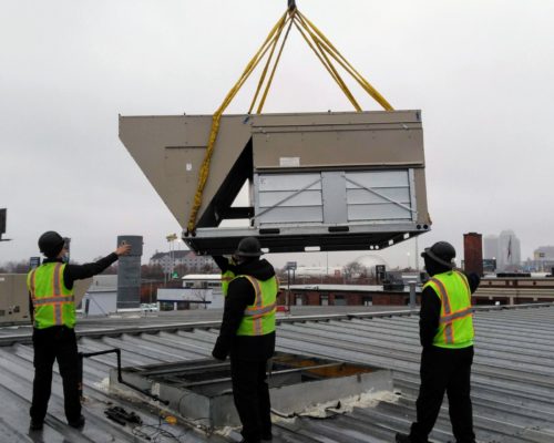 Men Installing New HVAC Unit On Rooftop